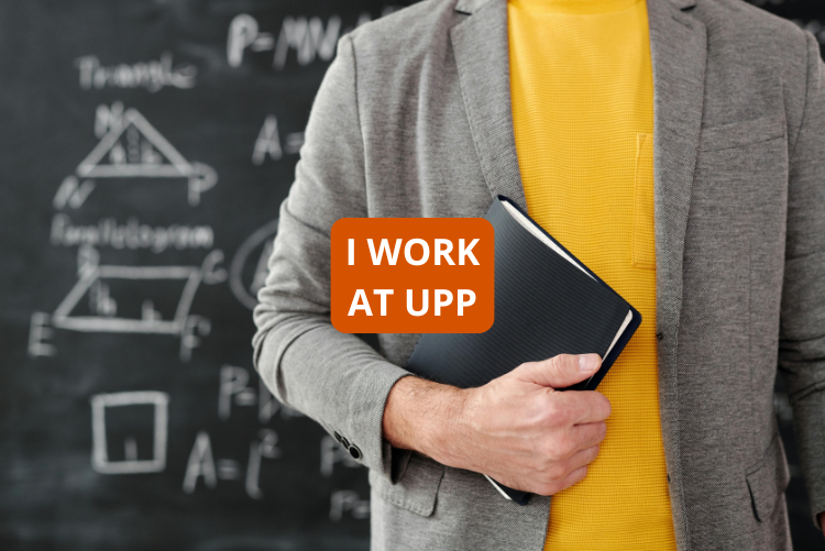 A photo of an academic lecturer in front of a board covered with formulas