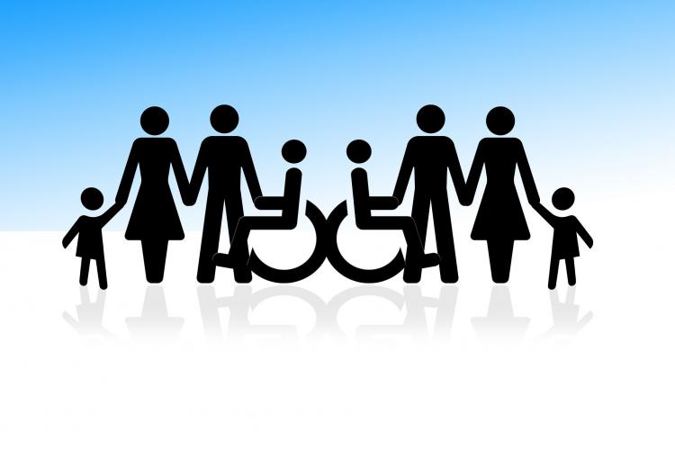Zdjęcie ilustracyjne, grafika przedstawiająca dwie postacie na wózku trzymające się za ręce ze stojącymi osobami